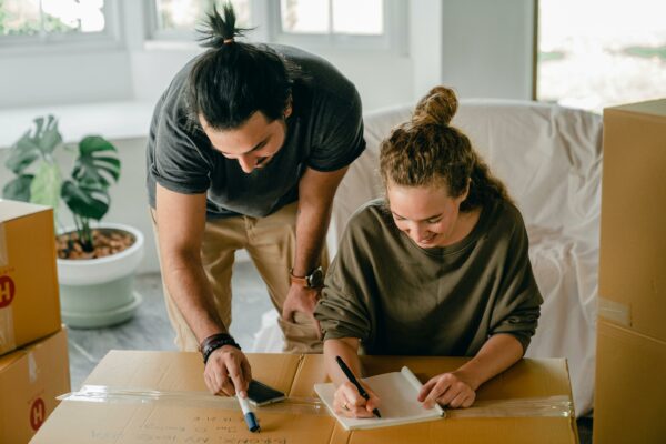 People writing on moving boxes - photo by Ketut Subiyanto via Pexels