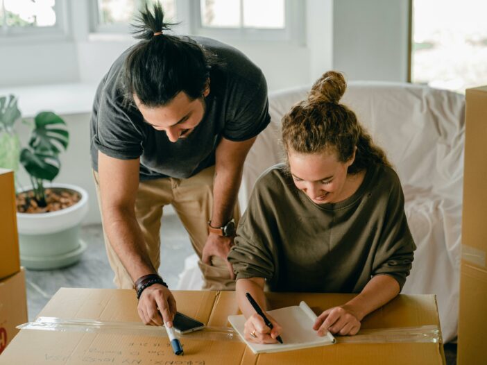 People writing on moving boxes - photo by Ketut Subiyanto via Pexels